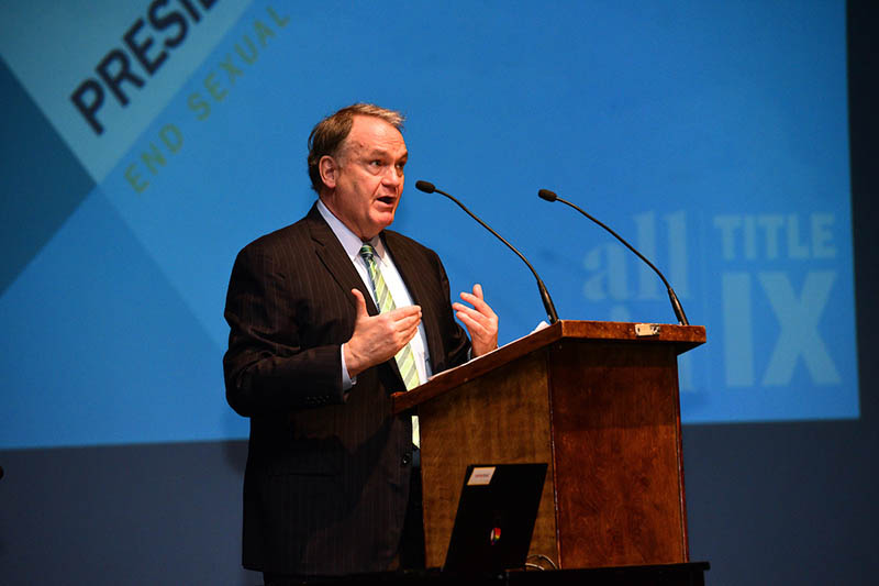 President Mike Fitts standing at a podium on stage talking to audience.